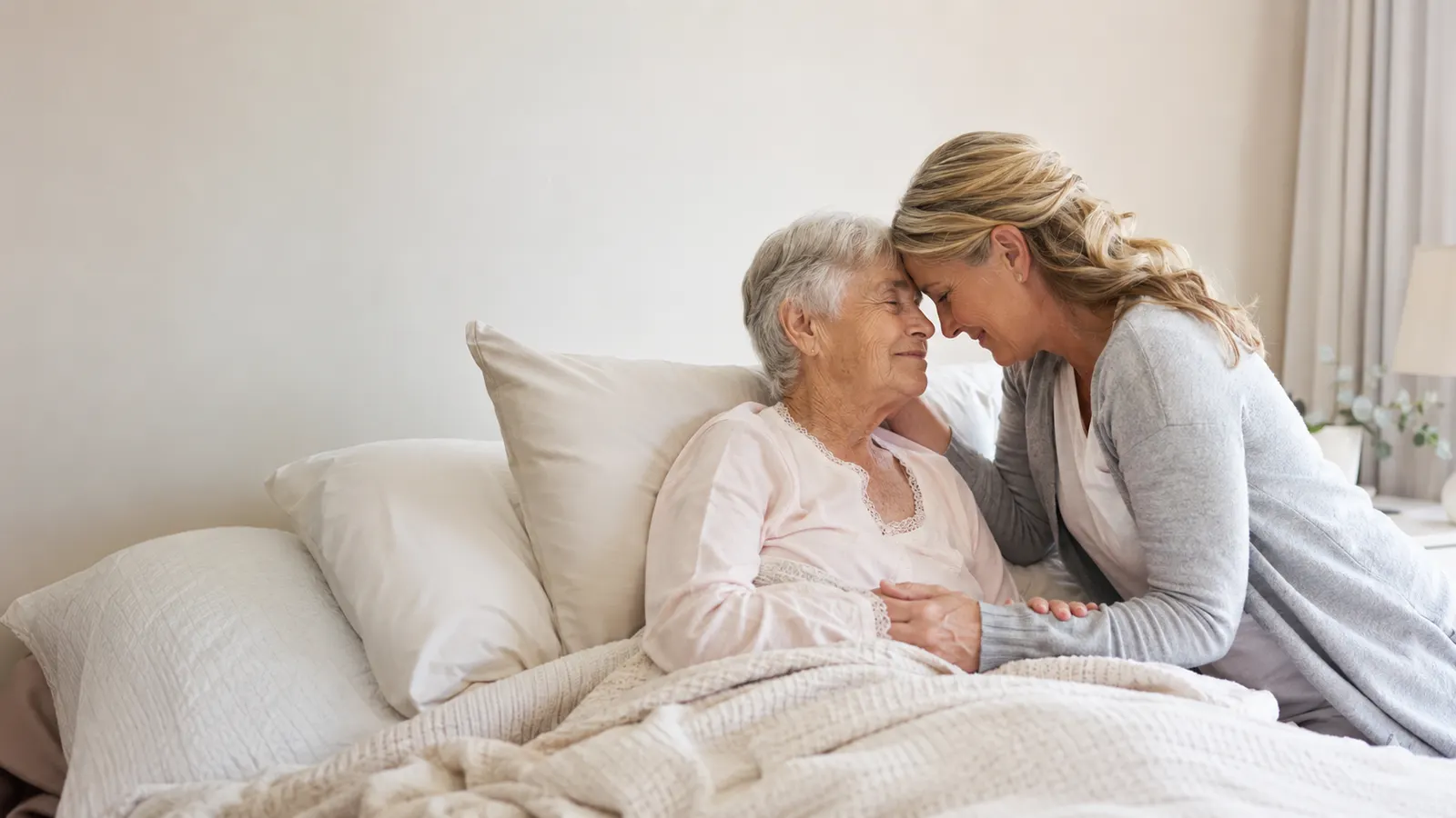 An adult child sitting calmly with an elderly parent at home